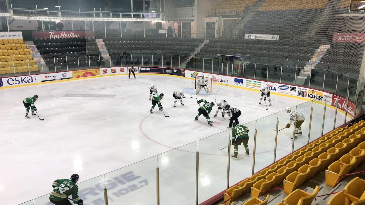 Deux équipes de hockey de la LHJMQ s'affrontent devant des gradins vides.