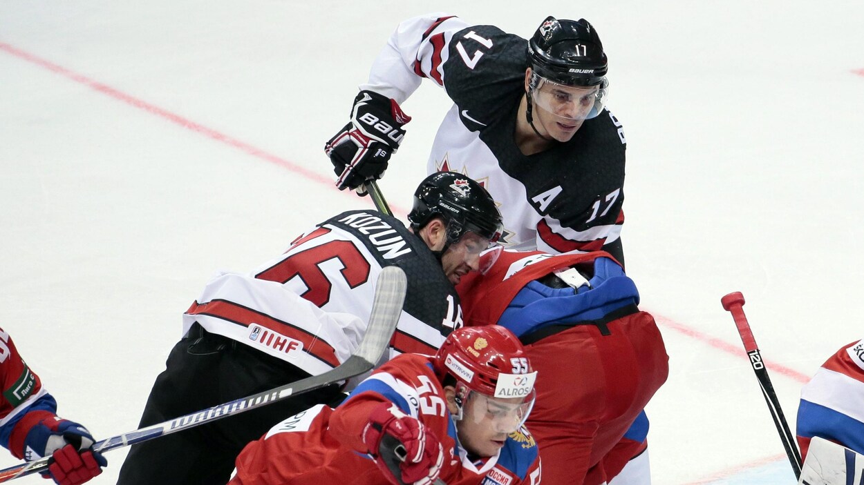 Rene Bourque (au haut de l'image) et Brandon Kozun (à gauche) tentent de se défaire de leurs adversaires russes à la Coupe Channel One, à Moscou. Rene Bourque (au haut de l'image) et Brandon Kozun (à gauche) tentent de se défaire de leurs adversaires russes à la Coupe Channel One, à Moscou.