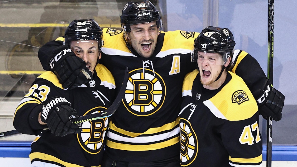 Trois joueurs de hockey se félicitent après le but vainqueur.