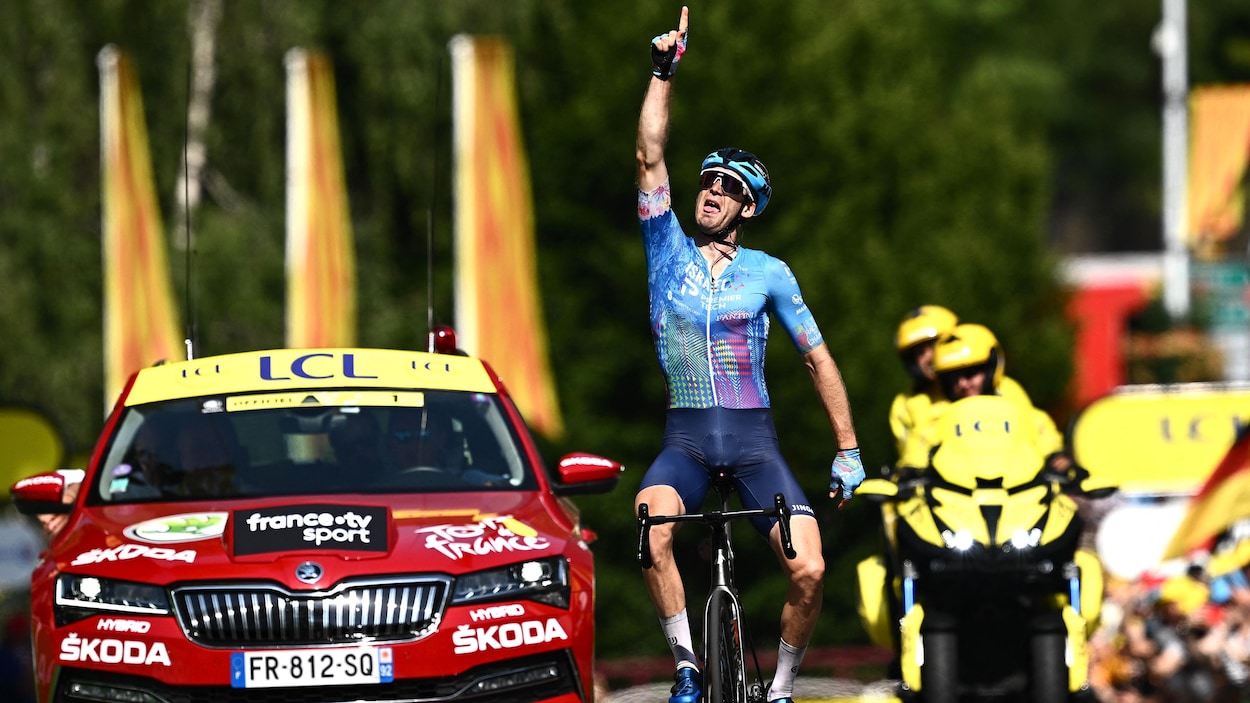 Le cycliste Hugo Houle lève un doigt vers le ciel après sa victoire.