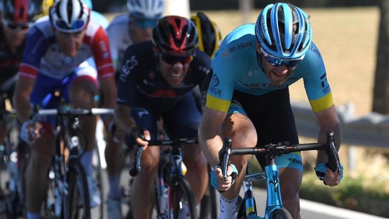 Il pédale à plein effort à l'avant d'un peloton.