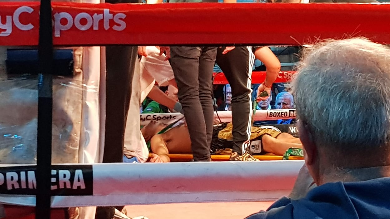 Il est couché sur une civière dans le ring.