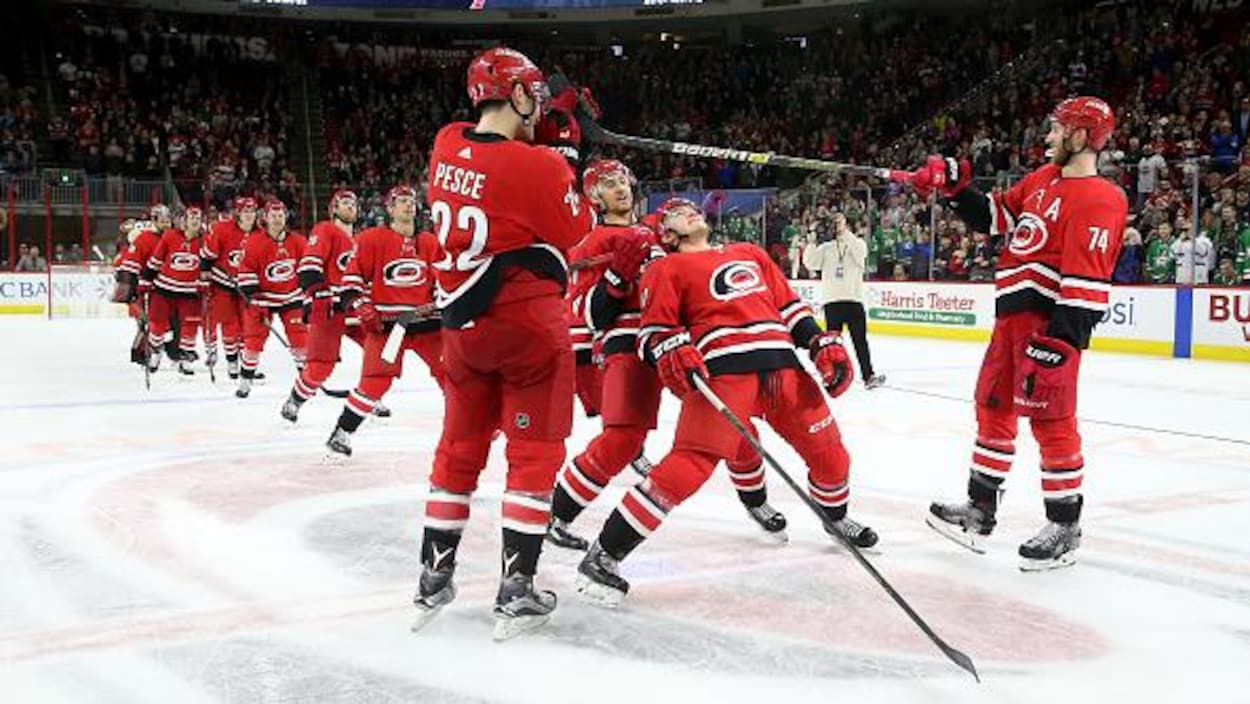 Les joueurs passent sous un bâton de hockey.