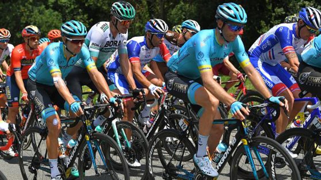 Les cyclistes roulent en peloton serré.