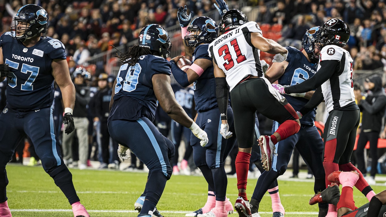 James Franklin lève le bras en guise de célébration, il est entouré de ses coéquipiers.