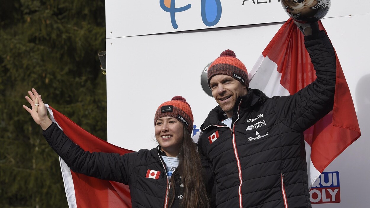 Les athlètes tiennent un drapeau du Canada.