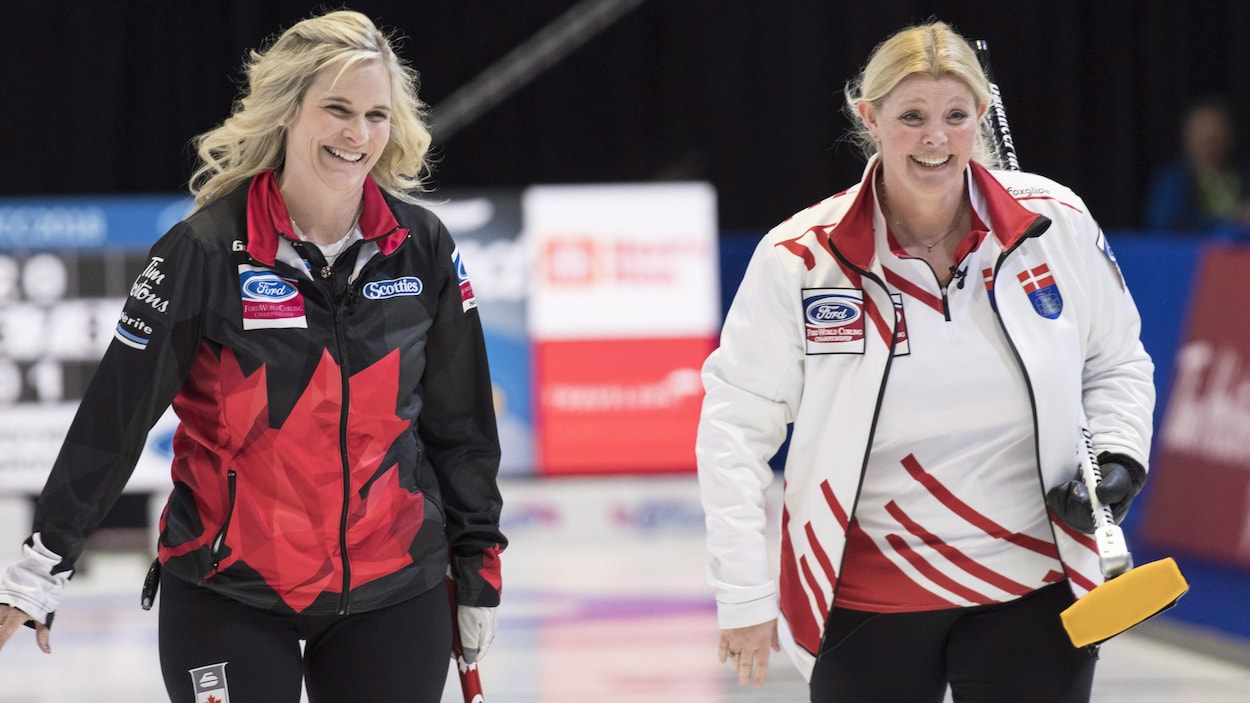 Les capitaines canadienne et danoise, Jennifer Jones et Angelina Jensen, rient en marchant côte-à-côte sur la patinoire. Les capitaines canadienne et danoise, Jennifer Jones et Angelina Jensen, rient en marchant côte-à-côte sur la patinoire.