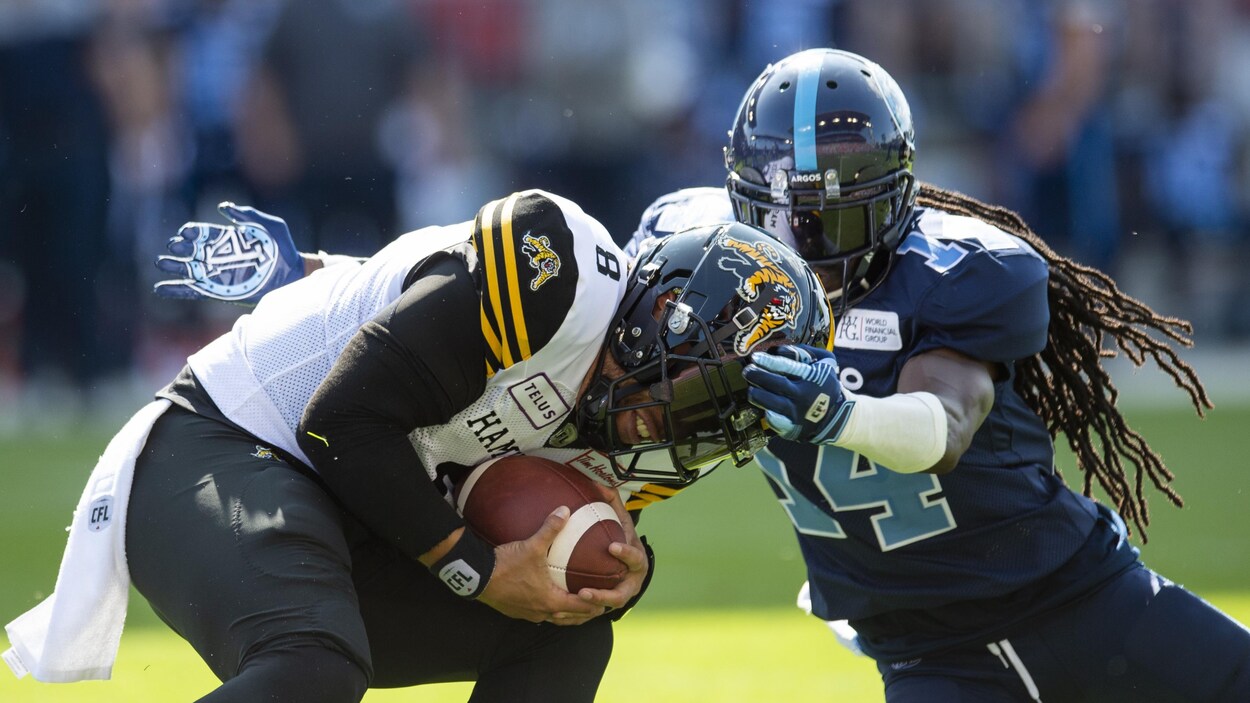 Jeremiah Masoli (à gauche) est plaqué par Abdul Kanneh.