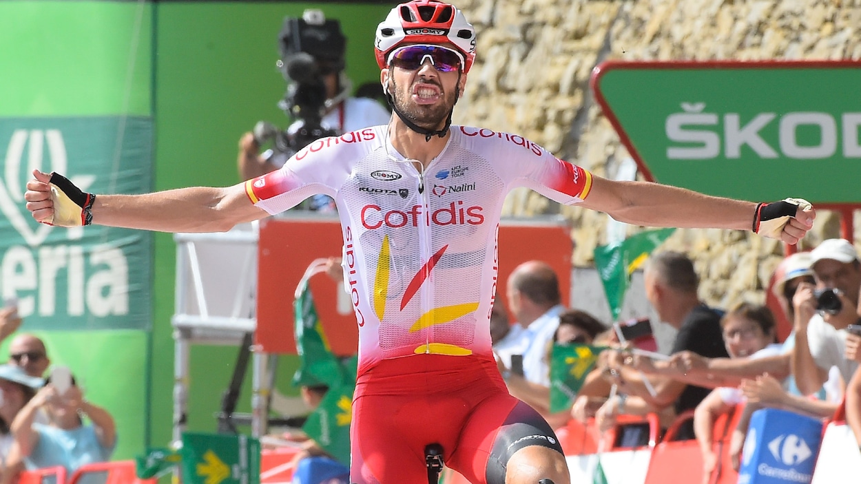 Il lève les bras pour célébrer sa victoire.