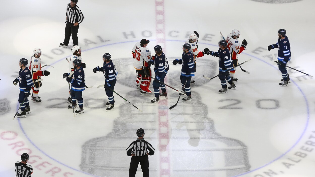 Les joueurs des Jets et des Flames se donnent la main à la suite de l'élimination des Jets.