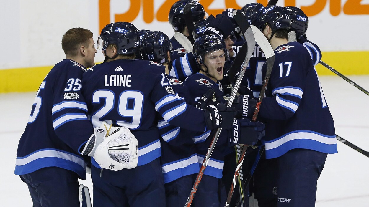 Les joueurs des Jets se rassemblent pour célébrer leur victoire. Les joueurs des Jets se rassemblent pour célébrer leur victoire.