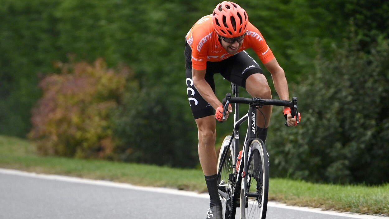 Le cycliste file à vive allure, debout sur ses pédales