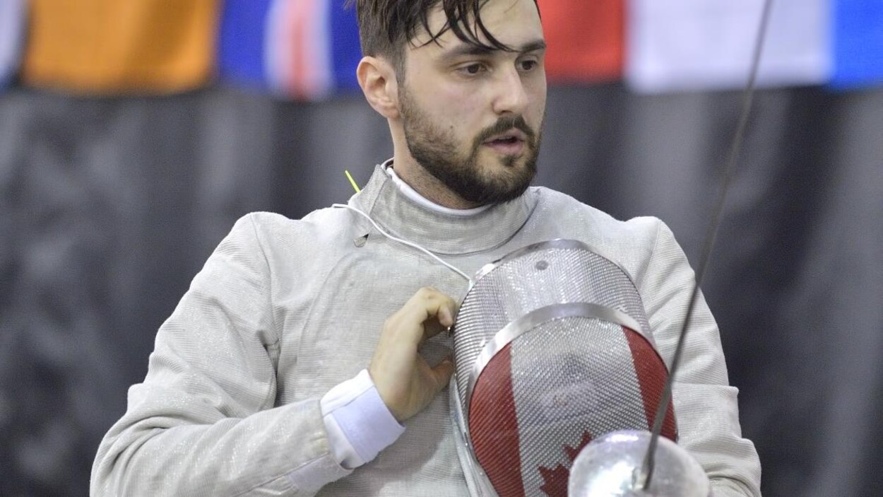 Un escrimeur retire son casque.