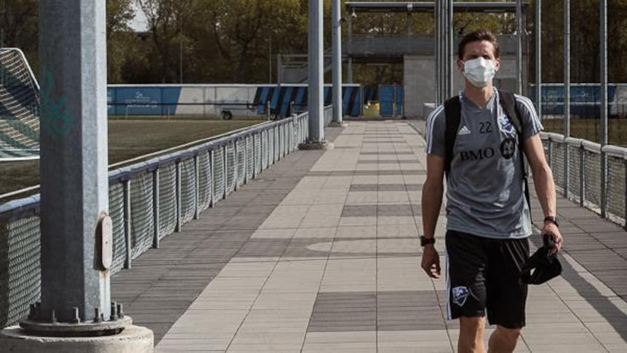 Il marche le long des terrains de soccer.