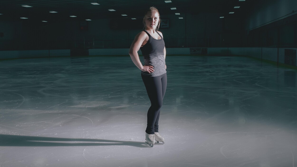 Julianne Séguin se tient debout sur une patinoire. Julianne Séguin se tient debout sur une patinoire.