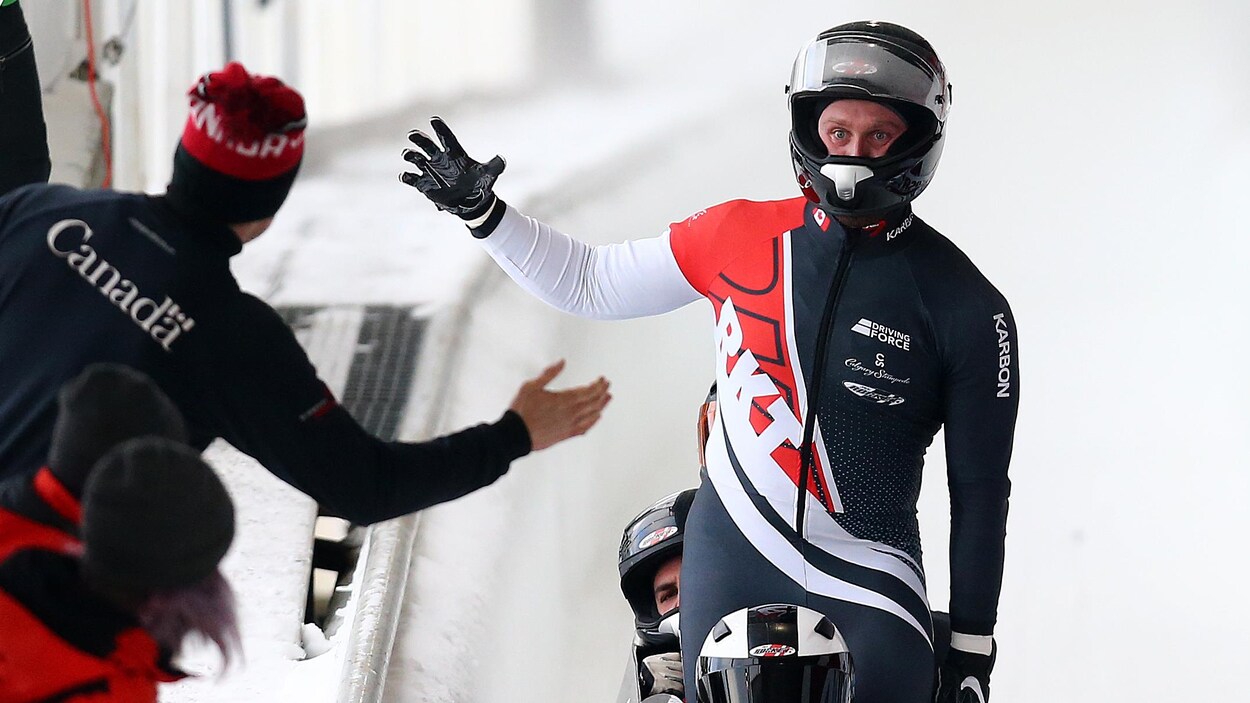Il s'apprête à taper dans la main de quelqu'un de l'équipe canadienne avec un regard intense.