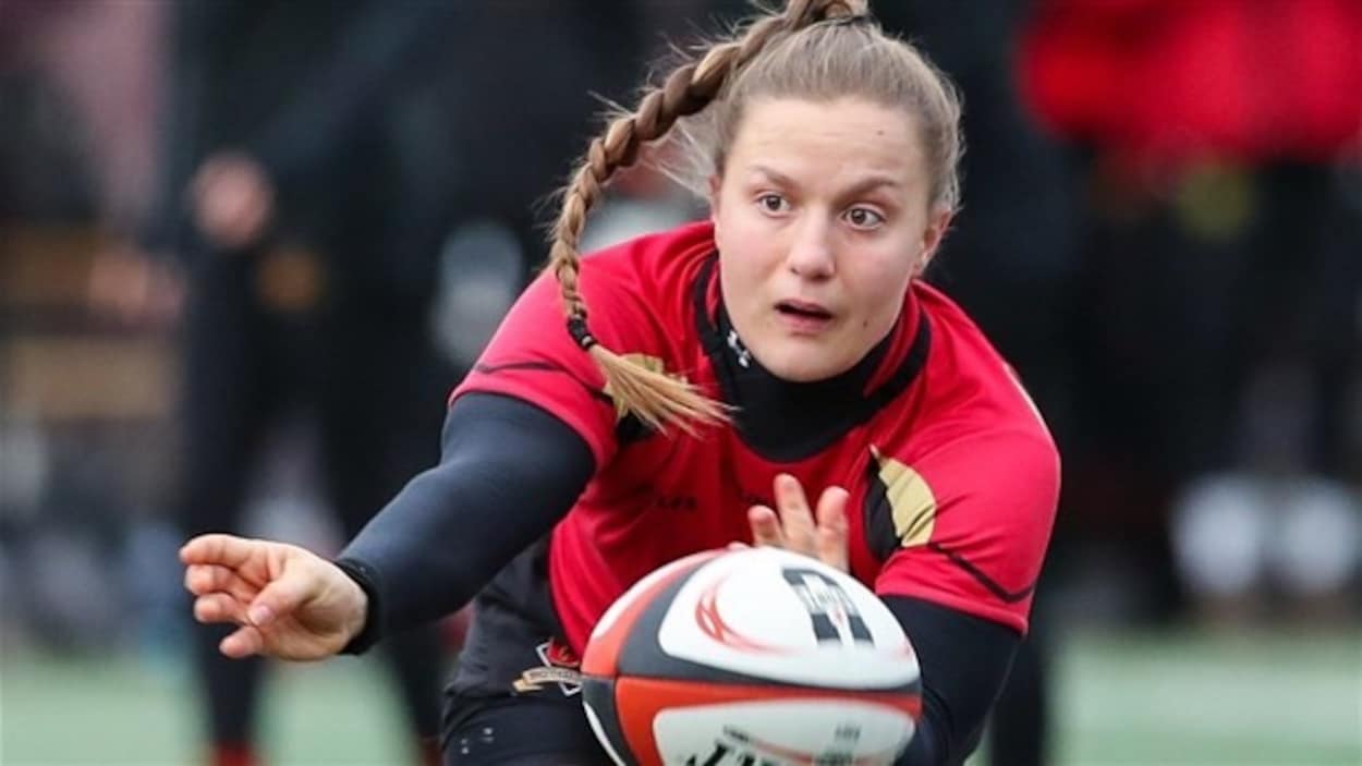 Une joueuse lance un ballon de rugby