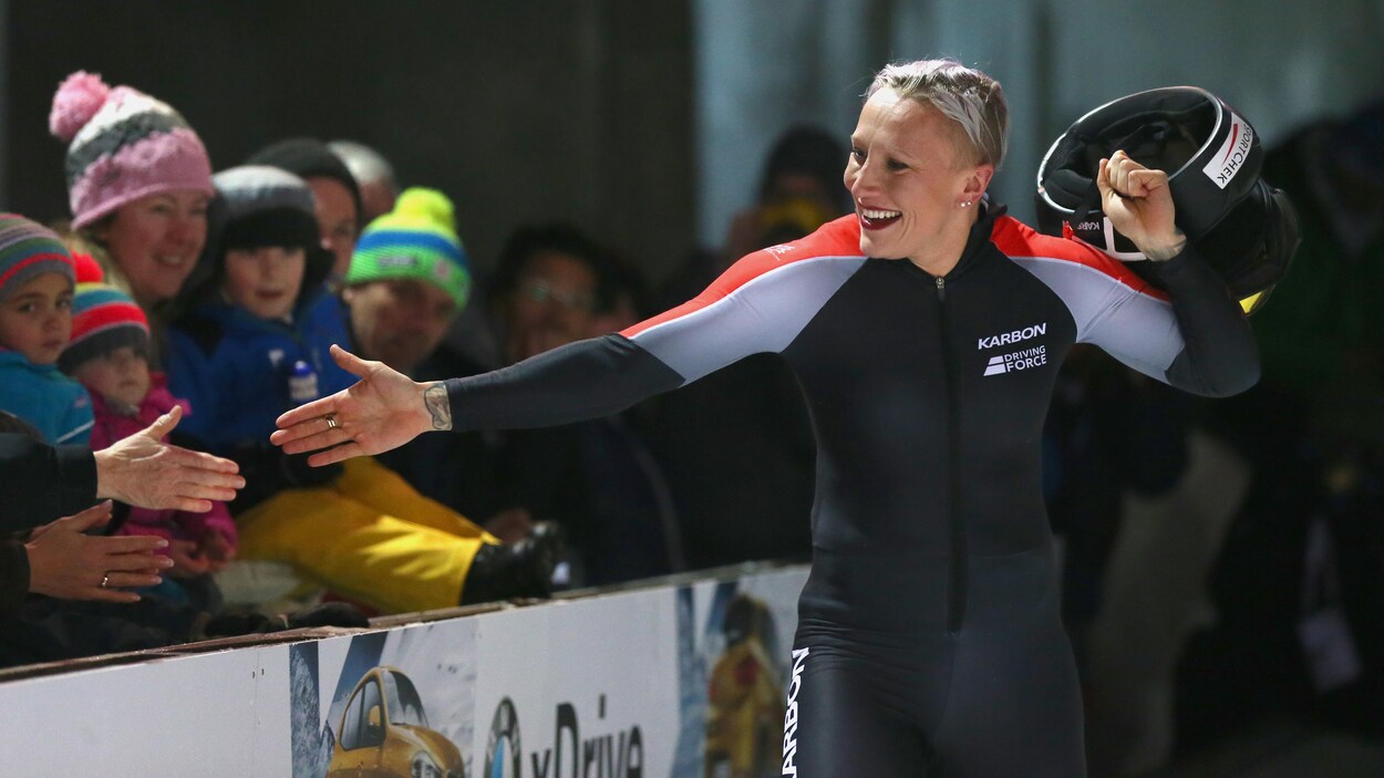 Kaillie Humphries enlève son casque en tendant la main à des spectateurs.