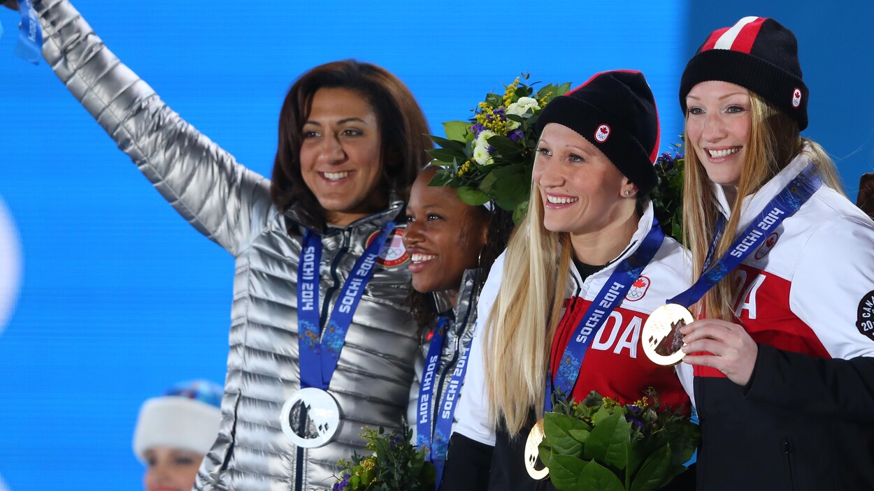 Les Américaines Elena Meyers et Taylor et Lauryn Williams (à gauche) et les Canadiennes Kaillie Humphries et Heather Moyse (à droite) à la cérémonie de médailles des Jeux olympiques de Sotchi