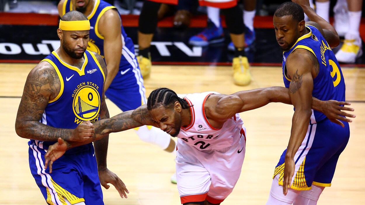 Kawhi Leonard (au centre) est surveillé étroitement par DeMarcus Cousins (à gauche) et Andre Iguodala.