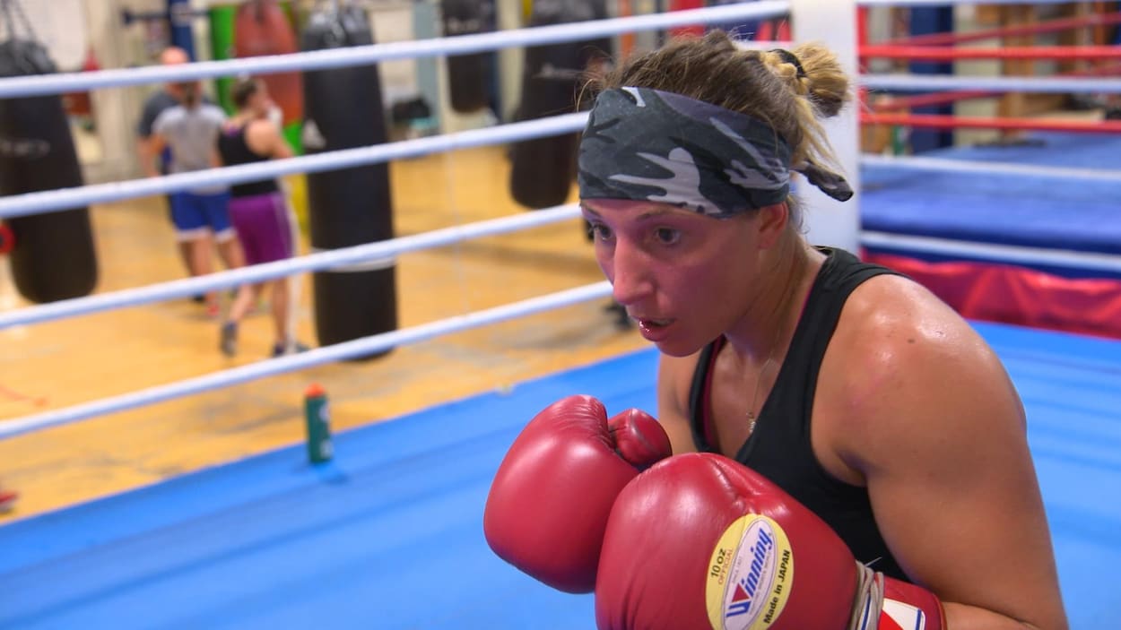 Une boxeuse avec des gants dans un gymnase
