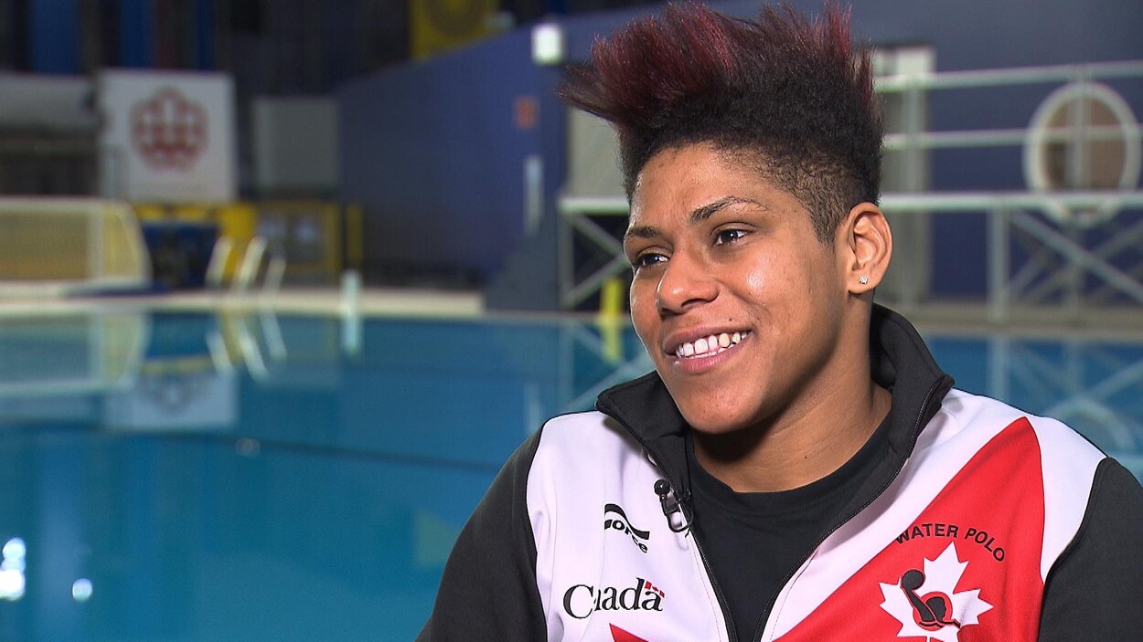 Elle donne une entrevue près d'une piscine.