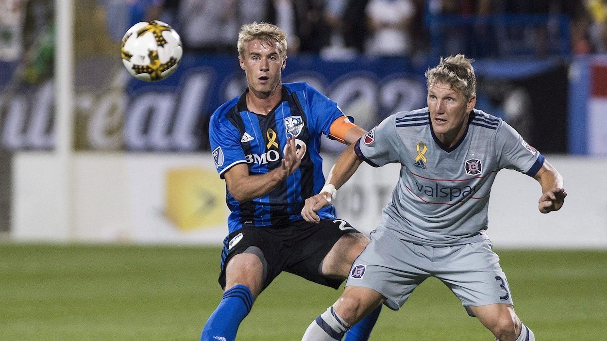 Le défenseur Kyle Fisher, de l'Impact de Montréal, lutte pour le ballon avec Bastian Schweinsteiger, du Fire de Chicago. Le défenseur Kyle Fisher, de l'Impact de Montréal, lutte pour le ballon avec Bastian Schweinsteiger, du Fire de Chicago.