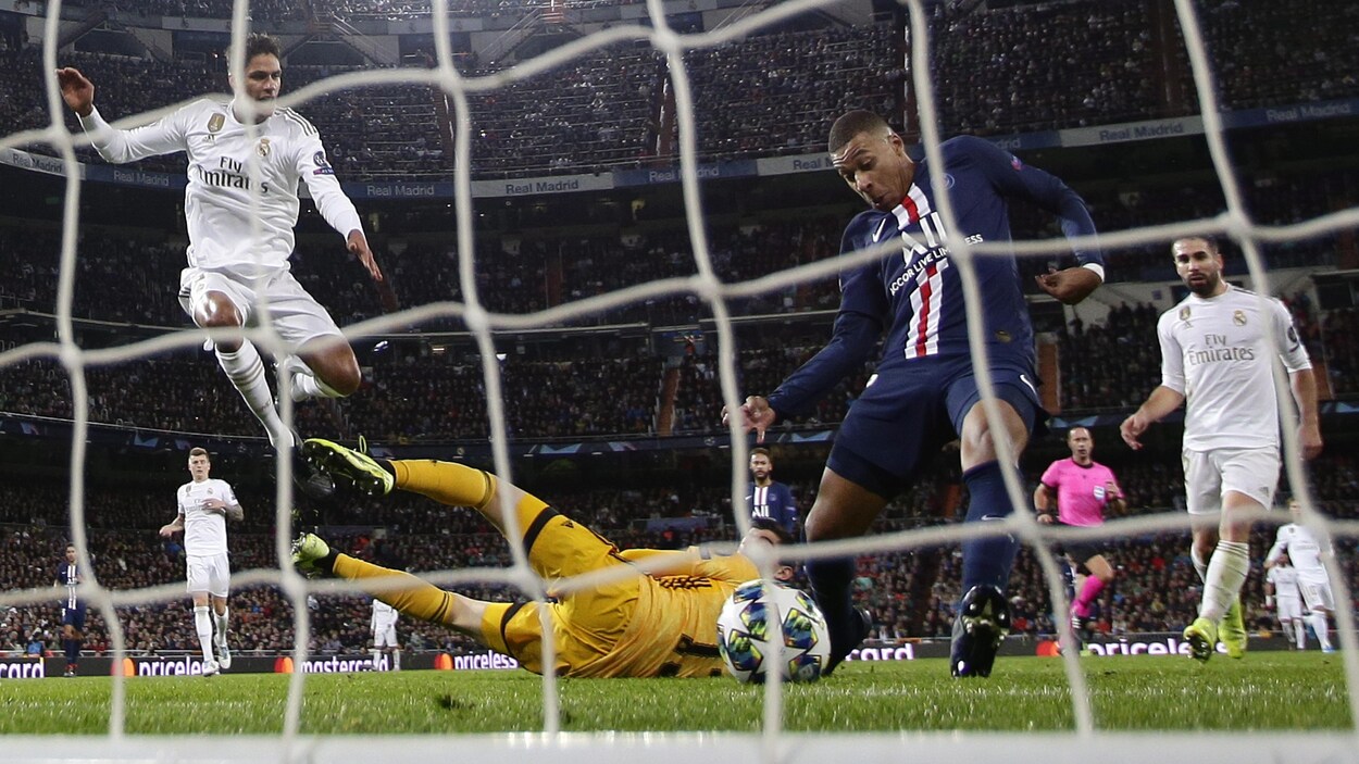 Il frappe le ballon du pied droit dans le filet.