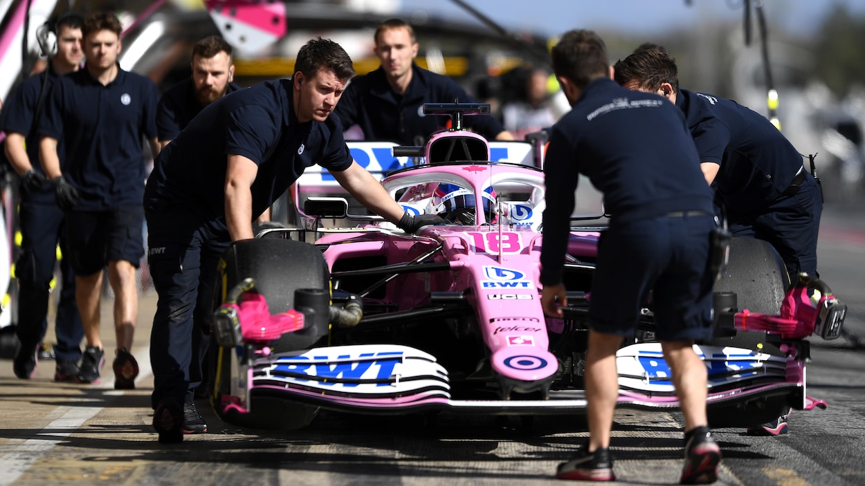 Les mécaniciens de Racing Point poussent la monoplace de Lance Stroll au circuit Catalunya de Barcelone.