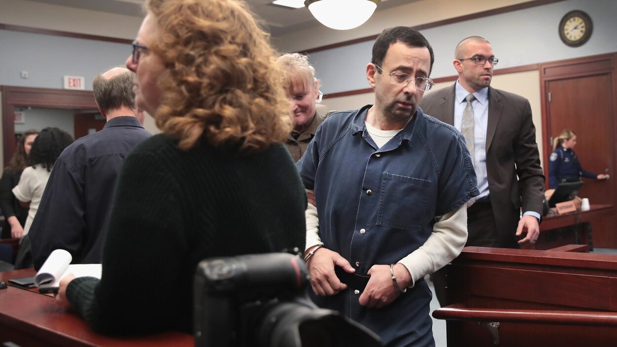Larry Nassar arrive au tribunal menotté et accompagné des forces de l'ordre.