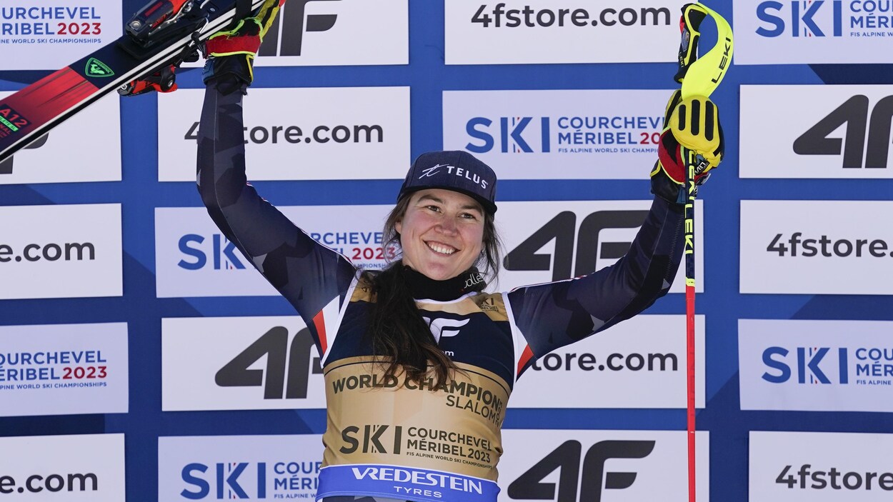 La skieuse Laurence St-Germain sourit sur le podium en levant ses bras.