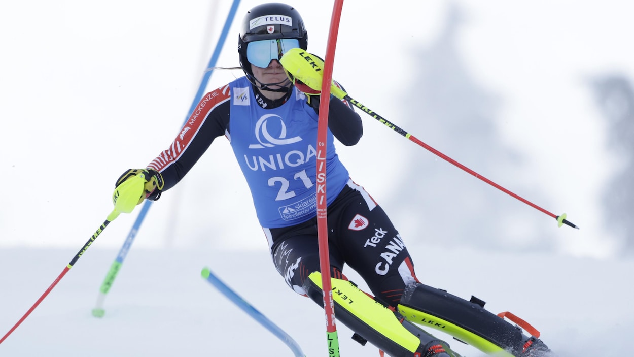 Une skieuse descend la piste lors d'une compétition de ski alpin.