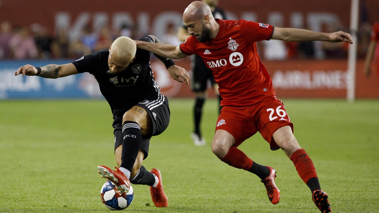 Il bataille pour le ballon avec Yohan Croizet du Sporting Kansas City.