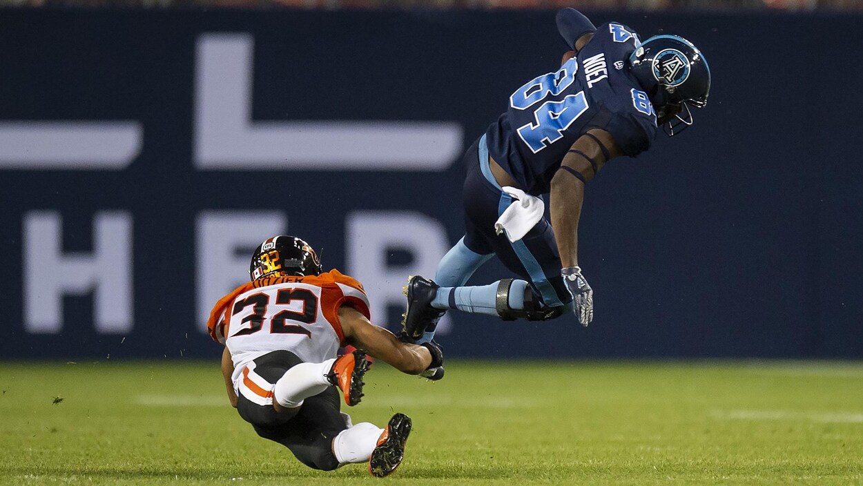 Le receveur des Argonauts Llevi Noel se fait plaquer par le demi défensif des Lions Branden Dozier.