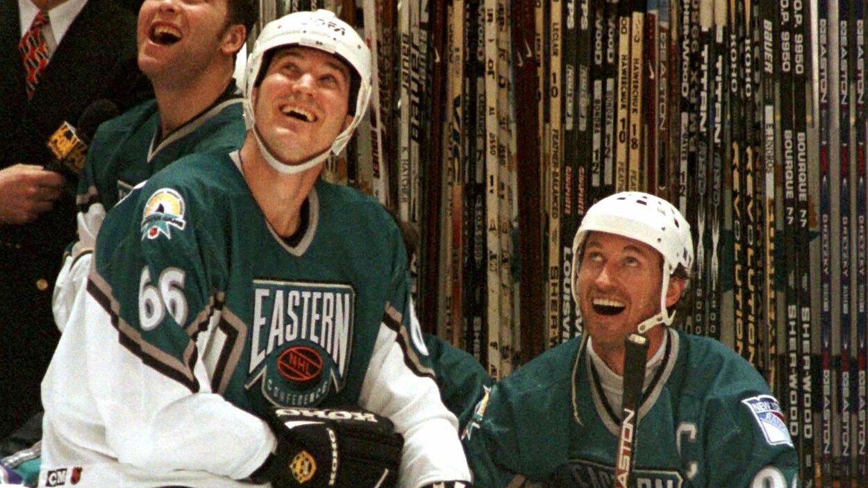 Deux joueurs au banc sourient.