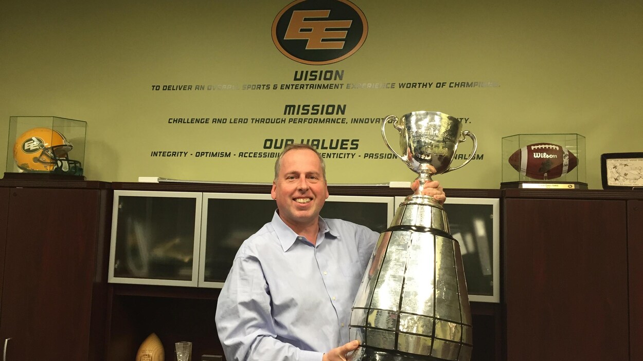 Len Rhodes soulève la Coupe dans son bureau au stade du Commonwealth.