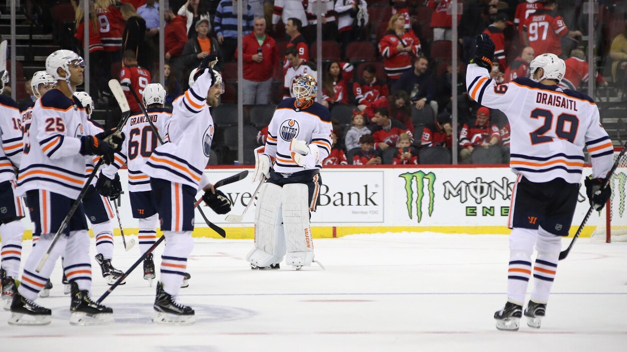 Il lève le bras gauche dans les airs près de ses coéquipiers des Oilers après son but vainqueur.