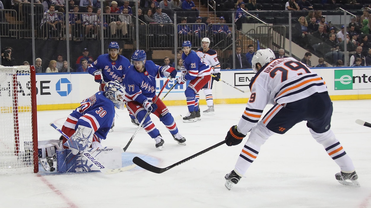 Henrik Lundqvist tente un arrêt devant le filet des Rangers de New York, menacé par Leon Draisaitl.