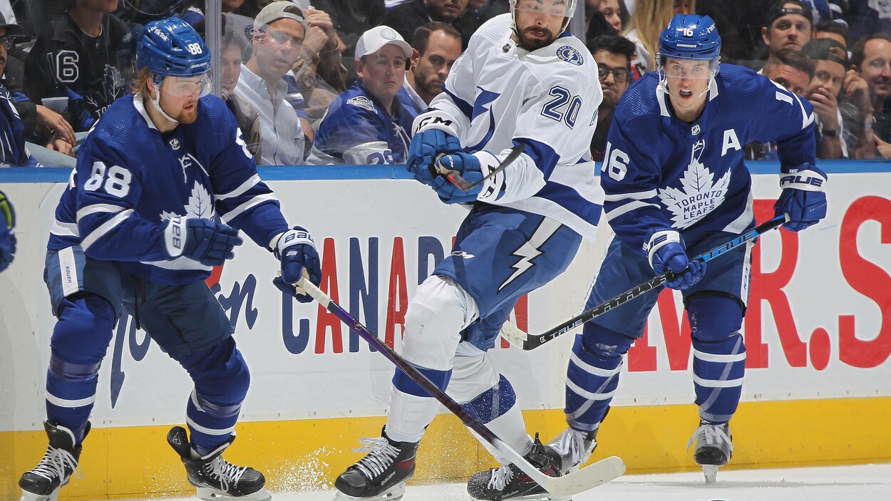 Nick Paul se baille pour la rondelle entre William Nylander et Mitchell Marner.