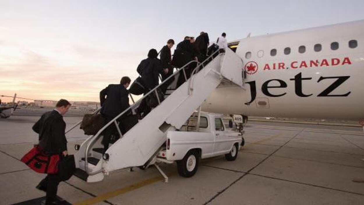 Des joueurs montent dans un avion d'Air Canada.