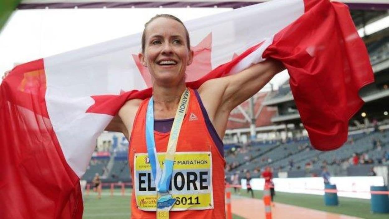 Sourire aux lèvres, elle porte le drapeau canadien sur ses épaules.