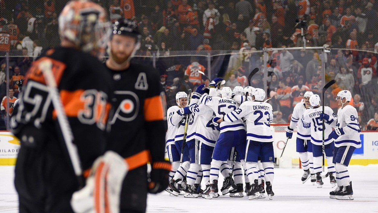 Deux joueurs des Flyers sont visibles à l'avant-plan.