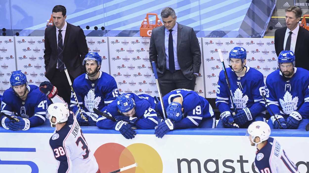 Des joueurs de hockey à la mine déconfite alors que célèbrent leurs adversaires.