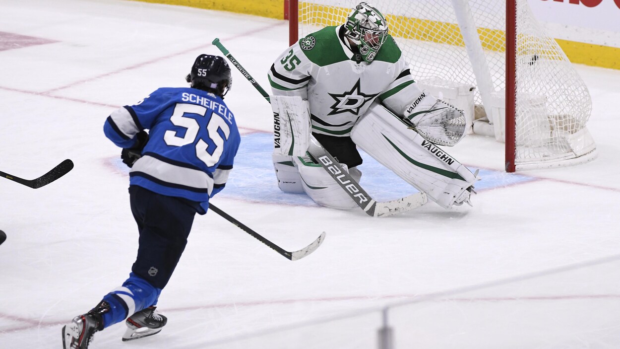 Un joueur de hockey marque un but.