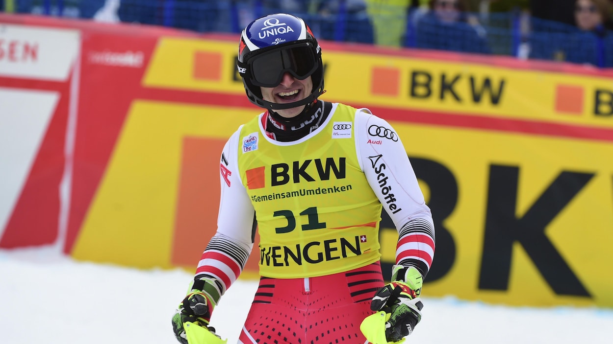 Un skieur sourit au bas de la piste.