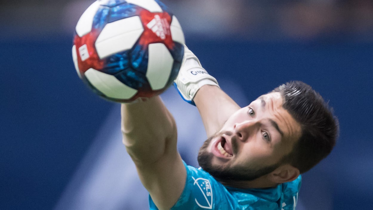 Il touche le ballon de la main gauche.