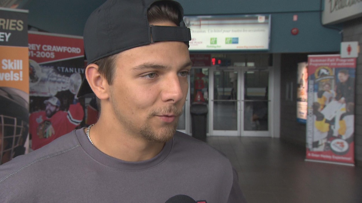 Mika Cyr, avec sa barbichette, portant une casquette à l'envers, donne une entrevue.