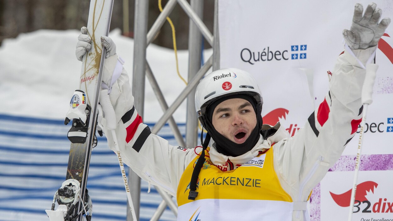 Il tient ses skis dans les mains