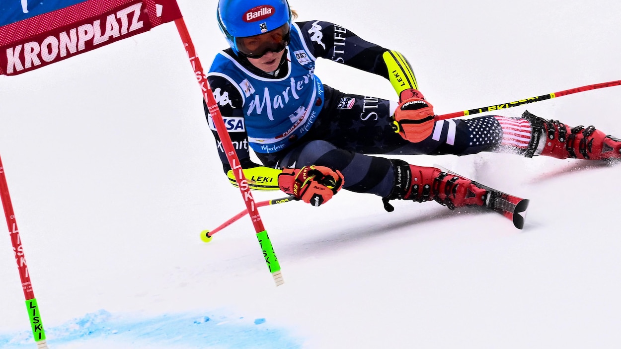 Une skieuse casquée négocie une porte sur sa droite lors d'une course.