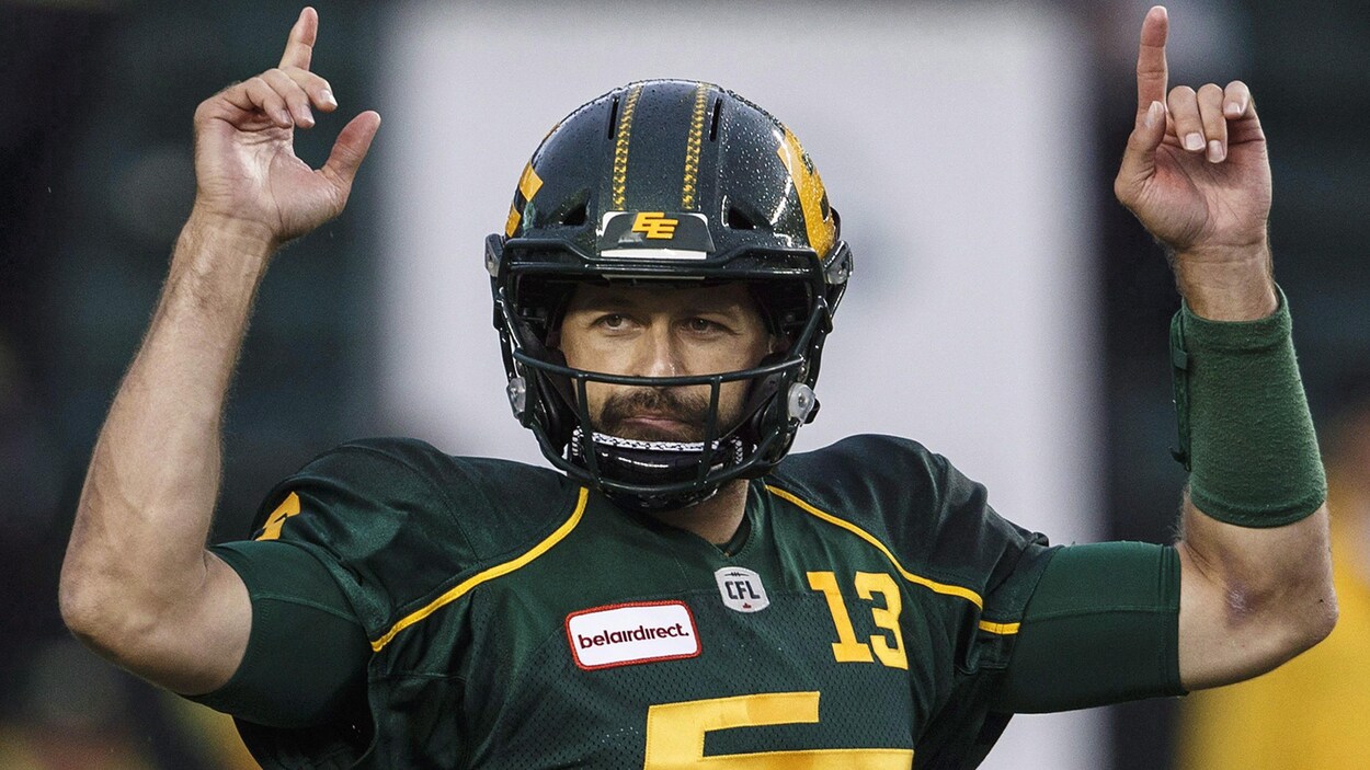 Mike Reilly, les bras dans les airs, donnent des signaux à ses coéquipiers.